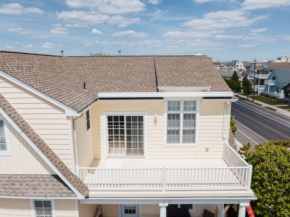 An aerial view of a two-story home's roof and deck.