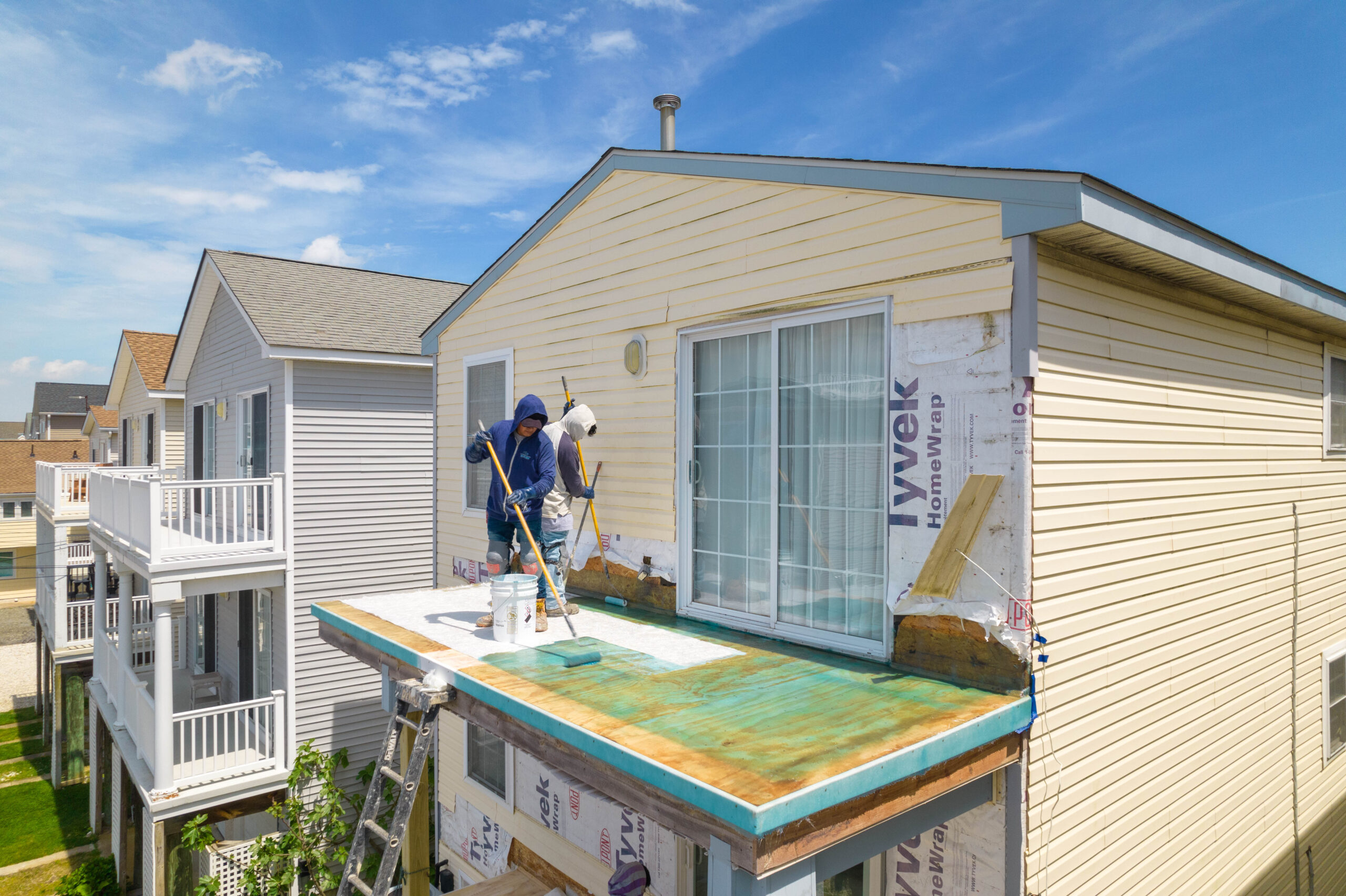 Workers from OC Fiberglass applying a coating on a deck.